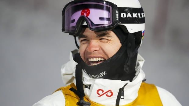 A smiling male freestyle skier.