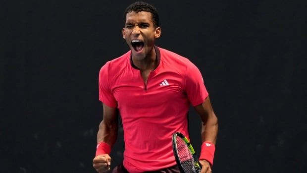 A male tennis player reacts after winning a match point.