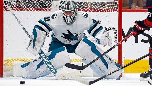 A puck slides in front of San Jose Sharks goaltender Vitek Vanecek during the first period of an NHL regular-season game in Raleigh, N.C., on December 10, 2024. 