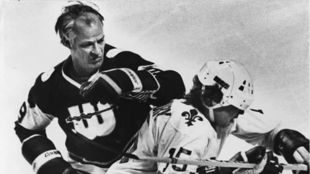 A hockey player checks another in the late 1970s.