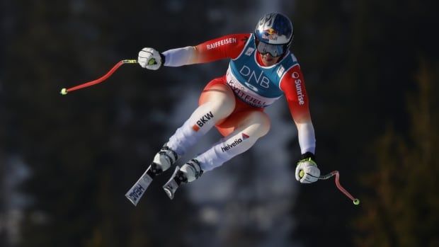 A male alpine skier soars through the air.