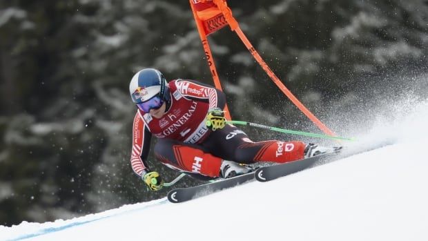 A male alpine skier races down a super-G course.