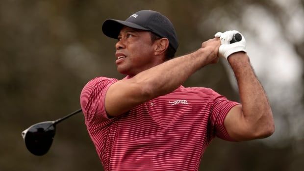 A men's golfer watches his tee shot.